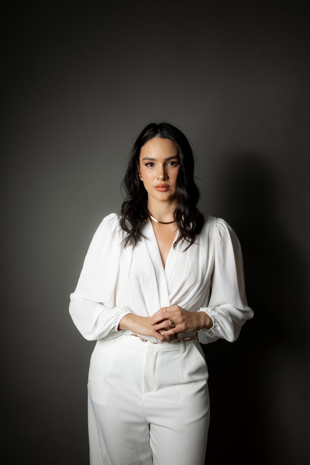 Dra. Julianna Munilla de blusa branca, em fundo escuro